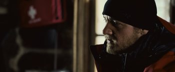 Movie still from “The Bourne Legacy” (2012), directed by Tony Gilroy – A person with a beard wearing a jacket; Close Up shot, Low angle