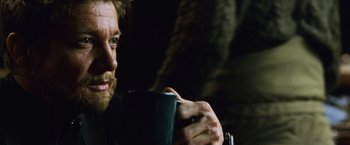 Movie still from “The Bourne Legacy” (2012), directed by Tony Gilroy – A person holding a cup of coffee; Close Up shot, Over the shoulder angle