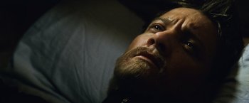 Movie still from “The Bourne Legacy” (2012), directed by Tony Gilroy – A person with a beard; Close Up shot, High angle