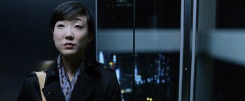 Movie still from “The Bourne Legacy” (2012), directed by Tony Gilroy – A woman standing in front of a window at night; Close Up shot, Over the shoulder angle