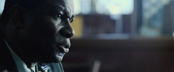 Movie still from “The Bourne Legacy” (2012), directed by Tony Gilroy – A man's face in a dark room; Close Up shot, Over the shoulder angle