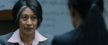 Movie still from “The Bourne Legacy” (2012), directed by Tony Gilroy – A woman in a business suit talking to a man in a business suit; Close Up shot, Over the shoulder angle