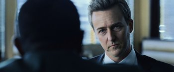 Movie still from “The Bourne Legacy” (2012), directed by Tony Gilroy – A person wearing a suit and tie; Close Up shot, Over the shoulder angle