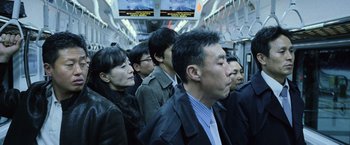 Movie still from “The Bourne Legacy” (2012), directed by Tony Gilroy – A group of men and women on a subway train; Medium shot, High angle