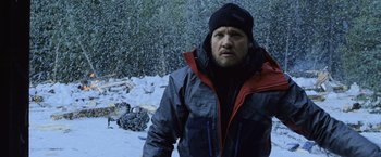 Movie still from “The Bourne Legacy” (2012), directed by Tony Gilroy – A man standing in the middle of a snow covered field; Close Up shot, Over the shoulder angle