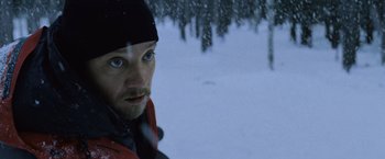 Movie still from “The Bourne Legacy” (2012), directed by Tony Gilroy – A person with a beard in the snow; Close Up shot, Low angle