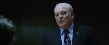 Movie still from “The Bourne Legacy” (2012), directed by Tony Gilroy – An older man wearing a suit and tie; Close Up shot, Low angle