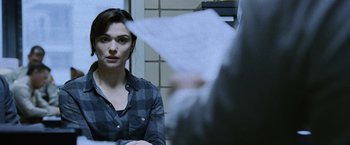 Movie still from “The Bourne Legacy” (2012), directed by Tony Gilroy – A woman sitting in front of a man in front of a wall; Close Up shot, Over the shoulder angle