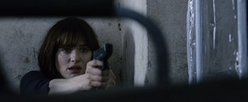 Movie still from “The Bourne Legacy” (2012), directed by Tony Gilroy – A woman holding a gun in front of a mirror; Close Up shot, High angle