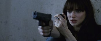 Movie still from “The Bourne Legacy” (2012), directed by Tony Gilroy – A woman is holding a gun in her hand; Close Up shot, Over the shoulder angle