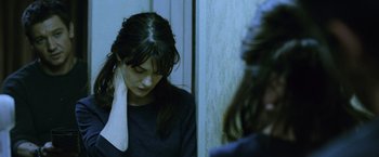 Movie still from “The Bourne Legacy” (2012), directed by Tony Gilroy – A woman with a towel around her neck looks in the mirror; Close Up shot, Over the shoulder angle