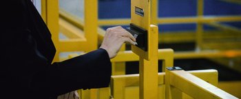 A person is putting money into a yellow box