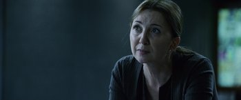 Movie still from “The Bourne Legacy” (2012), directed by Tony Gilroy – A person sitting in front of a window; Close Up shot, Over the shoulder angle