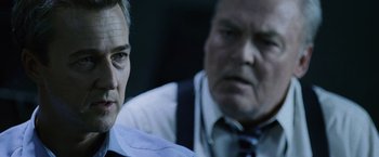 Movie still from “The Bourne Legacy” (2012), directed by Tony Gilroy – Two men in business suits are looking at each other; Close Up shot, Over the shoulder angle