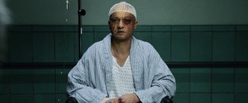 Movie still from “The Bourne Legacy” (2012), directed by Tony Gilroy – A man with a bandage on his head and face; Close Up shot, High angle