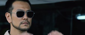 Movie still from “The Bourne Legacy” (2012), directed by Tony Gilroy – A person wearing sunglasses; Close Up shot, Over the shoulder angle
