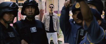 Movie still from “The Bourne Legacy” (2012), directed by Tony Gilroy – A man standing in front of a group of people; Medium shot, Low angle