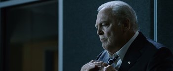 Movie still from “The Bourne Legacy” (2012), directed by Tony Gilroy – An older man wearing a suit and tie; Close Up shot, Low angle