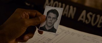 Movie still from “The Bourne Supremacy” (2004), directed by Paul Greengrass – A person holding a picture of a man; Extreme Close Up shot, Overhead angle