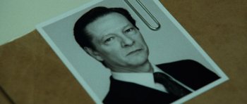Movie still from “The Bourne Supremacy” (2004), directed by Paul Greengrass – A black and white photo of a man in a suit and tie; Extreme Close Up shot, High angle
