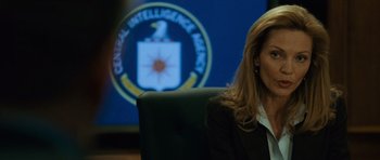 Movie still from “The Bourne Supremacy” (2004), directed by Paul Greengrass – A woman sitting at a desk in front of a large screen; Close Up shot, Over the shoulder angle