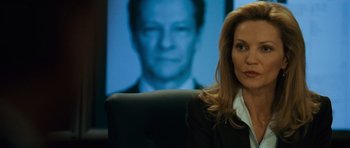 Movie still from “The Bourne Supremacy” (2004), directed by Paul Greengrass – A woman sitting in front of a picture of a man; Close Up shot, Over the shoulder angle