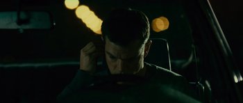 Movie still from “The Bourne Supremacy” (2004), directed by Paul Greengrass – A man sitting in the driver's seat of a car at night; Close Up shot, Over the shoulder angle