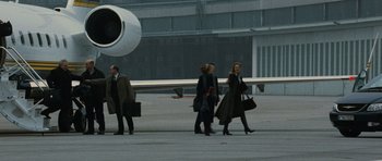 Movie still from “The Bourne Supremacy” (2004), directed by Paul Greengrass – A group of people walking on a runway near an airplane; Wide shot, Low angle