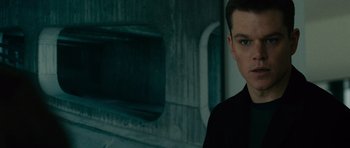 Movie still from “The Bourne Supremacy” (2004), directed by Paul Greengrass – A man in black shirt standing in front of a building; Close Up shot, Low angle