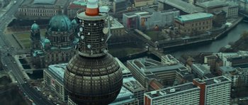 Movie still from “The Bourne Supremacy” (2004), directed by Paul Greengrass – An aerial view of a large building with a tower on top of it; Extreme Wide shot, High angle
