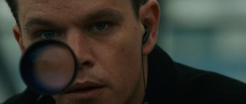 Movie still from “The Bourne Supremacy” (2004), directed by Paul Greengrass – A man wearing ear buds; Close Up shot, Over the shoulder angle