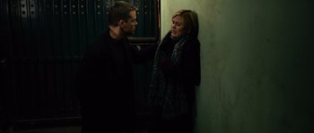 Movie still from “The Bourne Supremacy” (2004), directed by Paul Greengrass – A man and a woman standing next to each other near a wall; Medium shot, Low angle
