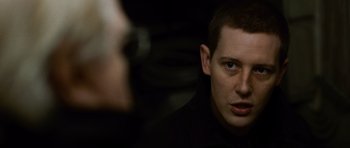 Movie still from “The Bourne Supremacy” (2004), directed by Paul Greengrass – A man in a black shirt is looking at the camera; Close Up shot, Over the shoulder angle