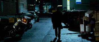 Movie still from “The Bourne Supremacy” (2004), directed by Paul Greengrass – A man walking down a street at night; Wide shot, Over the shoulder angle