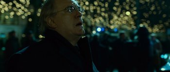 Movie still from “The Bourne Supremacy” (2004), directed by Paul Greengrass – An older man wearing glasses and a black jacket; Close Up shot, Low angle