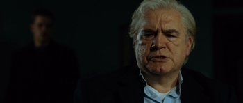 Movie still from “The Bourne Supremacy” (2004), directed by Paul Greengrass – An older man with white hair and a white shirt; Close Up shot, Low angle
