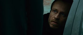 Movie still from “The Bourne Supremacy” (2004), directed by Paul Greengrass – A person with glasses looking at the camera; Close Up shot, Over the shoulder angle