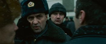 Movie still from “The Bourne Supremacy” (2004), directed by Paul Greengrass – Two men in winter coats and hats are standing in the street; Close Up shot, Low angle