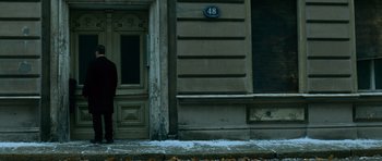 Movie still from “The Bourne Supremacy” (2004), directed by Paul Greengrass – A person standing in front of a building on a snowy day; Wide shot, Low angle