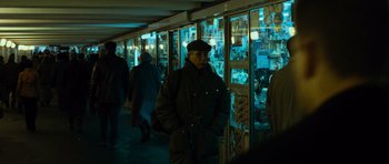 Movie still from “The Bourne Supremacy” (2004), directed by Paul Greengrass – A man walking down a street at night past a store window; Medium shot, Over the shoulder angle