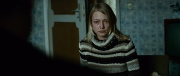 Movie still from “The Bourne Supremacy” (2004), directed by Paul Greengrass – A woman in a striped sweater looking at the camera; Close Up shot, Over the shoulder angle