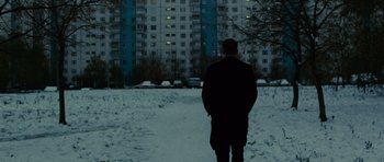 Movie still from “The Bourne Supremacy” (2004), directed by Paul Greengrass – A man is standing in front of a tall building; Wide shot, Low angle