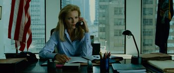 Movie still from “The Bourne Supremacy” (2004), directed by Paul Greengrass – A woman sitting at a desk talking on a phone; Medium shot, Over the shoulder angle