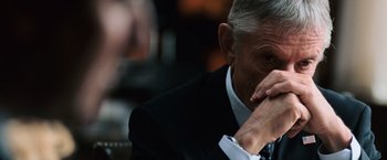 Movie still from “The Bourne Ultimatum” (2007), directed by Paul Greengrass – An older man wearing a suit and tie sitting in front of a mirror; Close Up shot, Over the shoulder angle