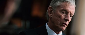 Movie still from “The Bourne Ultimatum” (2007), directed by Paul Greengrass – An older man wearing a suit and tie; Close Up shot, Over the shoulder angle