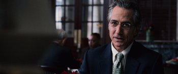 Movie still from “The Bourne Ultimatum” (2007), directed by Paul Greengrass – A man in a suit and tie in front of other people; Close Up shot, Over the shoulder angle