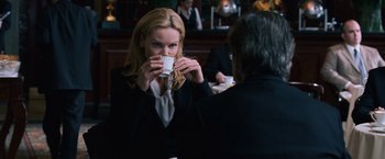 Movie still from “The Bourne Ultimatum” (2007), directed by Paul Greengrass – A woman drinking a cup of coffee at a restaurant; Medium shot, Over the shoulder angle