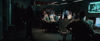 Movie still from “The Bourne Ultimatum” (2007), directed by Paul Greengrass – A group of people sitting around a room; Wide shot, High angle