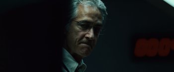 Movie still from “The Bourne Ultimatum” (2007), directed by Paul Greengrass – An older man wearing glasses and a white dress shirt; Close Up shot, Low angle