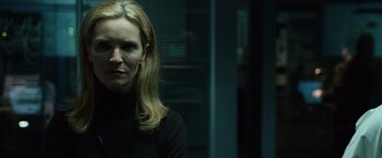 Movie still from “The Bourne Ultimatum” (2007), directed by Paul Greengrass – A woman in a black shirt is standing in a room; Close Up shot, Low angle